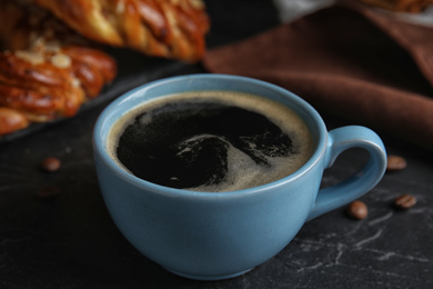 Photo of Delicious coffee and pastries on black table