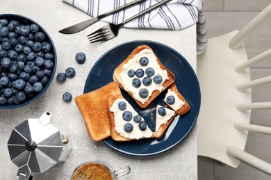 Photo of Tasty sandwiches with cream cheese and blueberries on grey table, flat lay