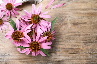 Photo of Beautiful blooming echinacea flowers on wooden table, flat lay. Space for text