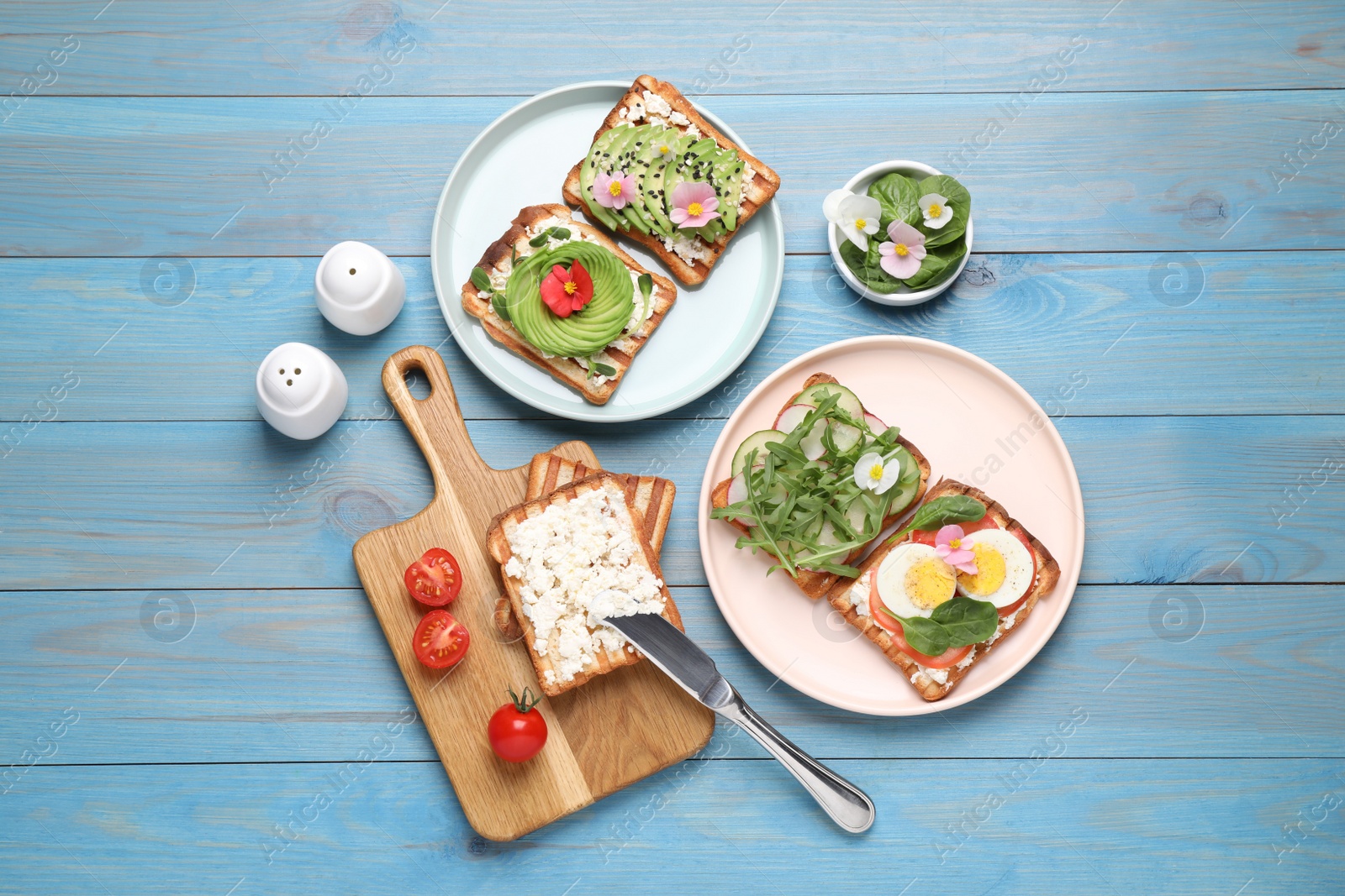 Photo of Different delicious sandwiches on light blue wooden table, flat lay