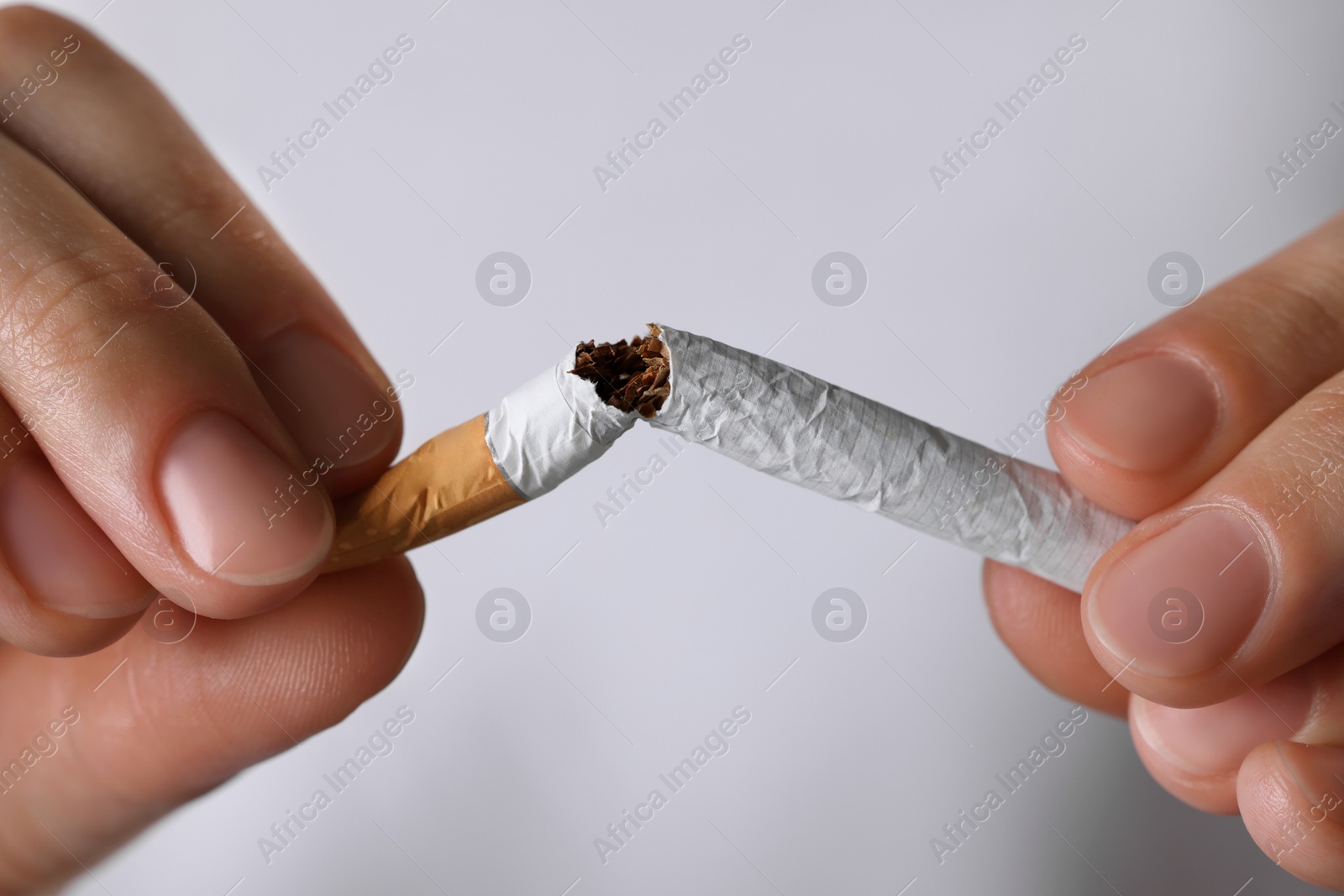 Photo of Stop smoking concept. Woman breaking cigarette, closeup