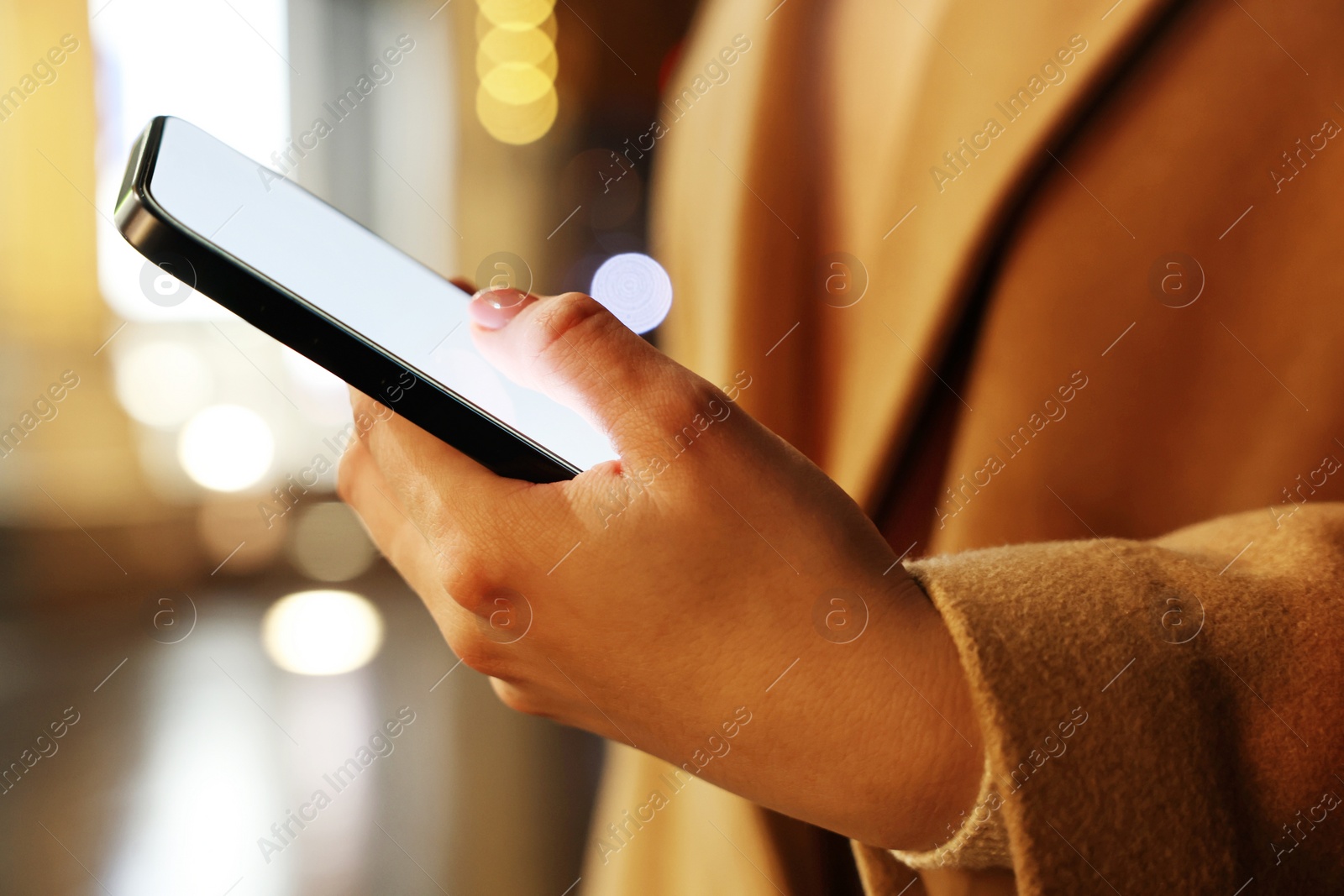 Photo of Woman using smartphone on night city street, closeup