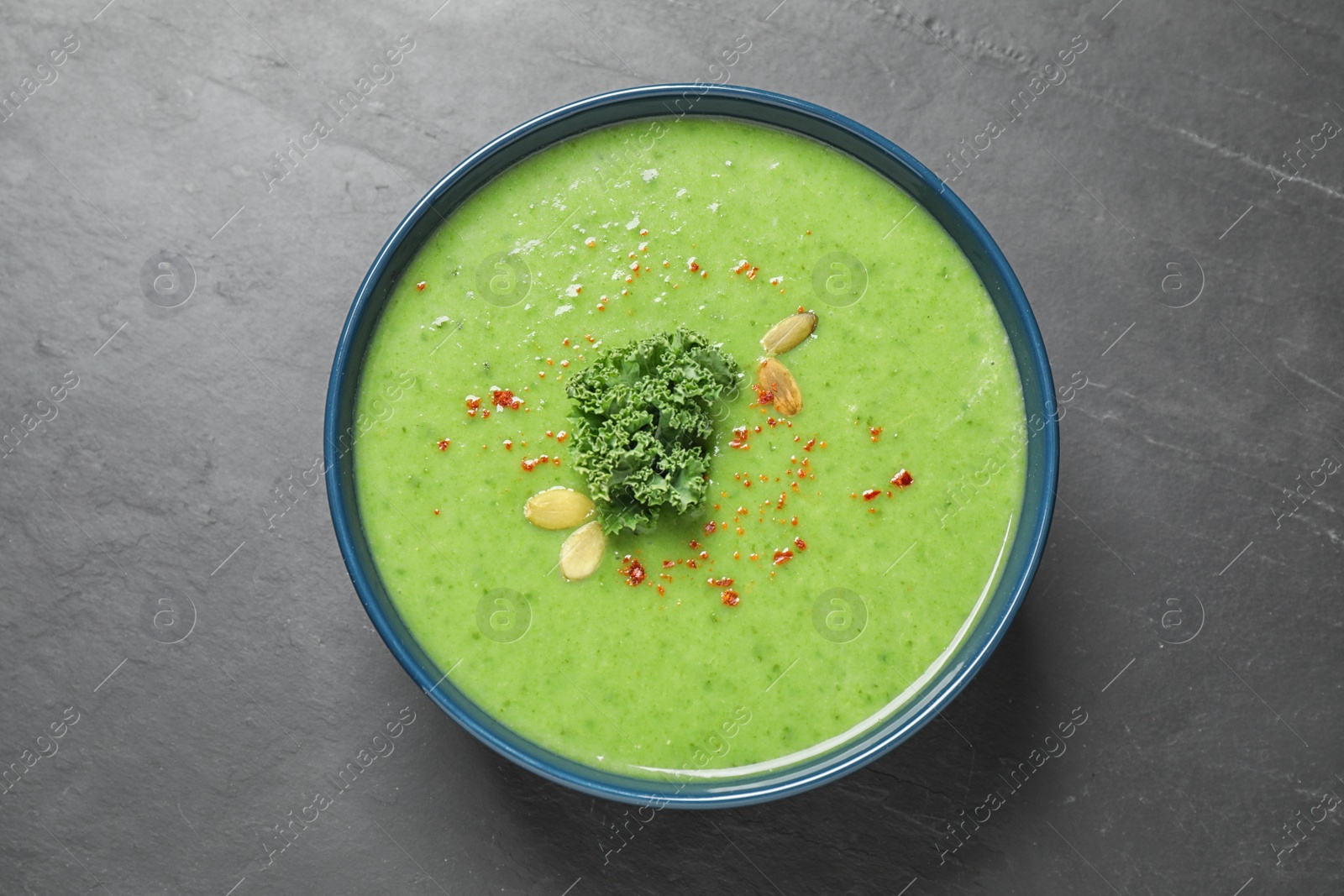 Photo of Tasty kale soup on grey table, top view