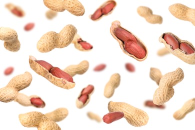 Image of Unpeeled peanuts in air on white background