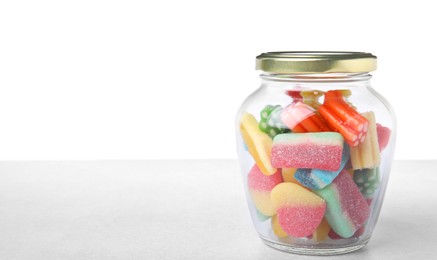 Tasty jelly candies in jar on light grey table