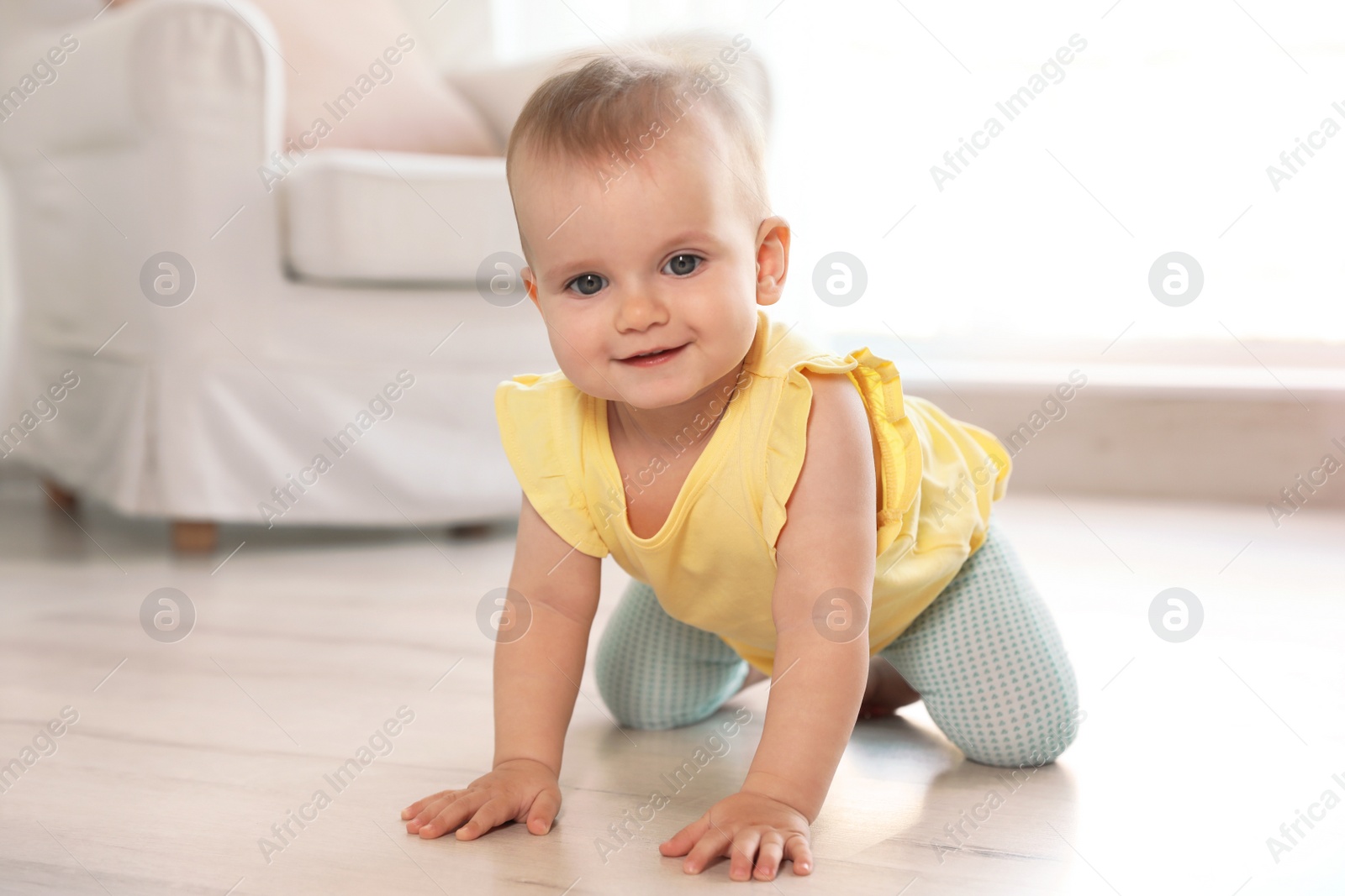 Photo of Cute baby girl on floor in room