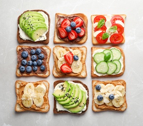 Photo of Tasty toast bread with fruits, berries and vegetables on light background