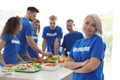 Photo of Team of volunteers near table with food indoors