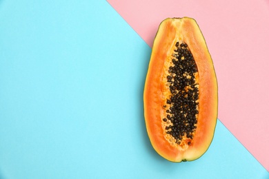 Photo of Fresh juicy halved papaya on color background, top view. Space for text