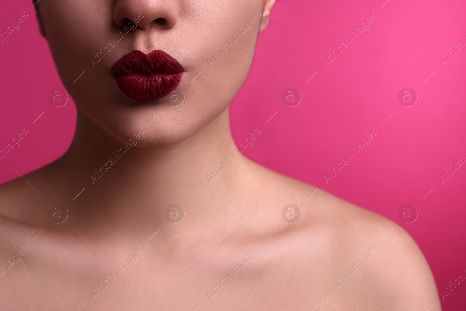 Photo of Closeup view of beautiful woman puckering lips for kiss on pink background