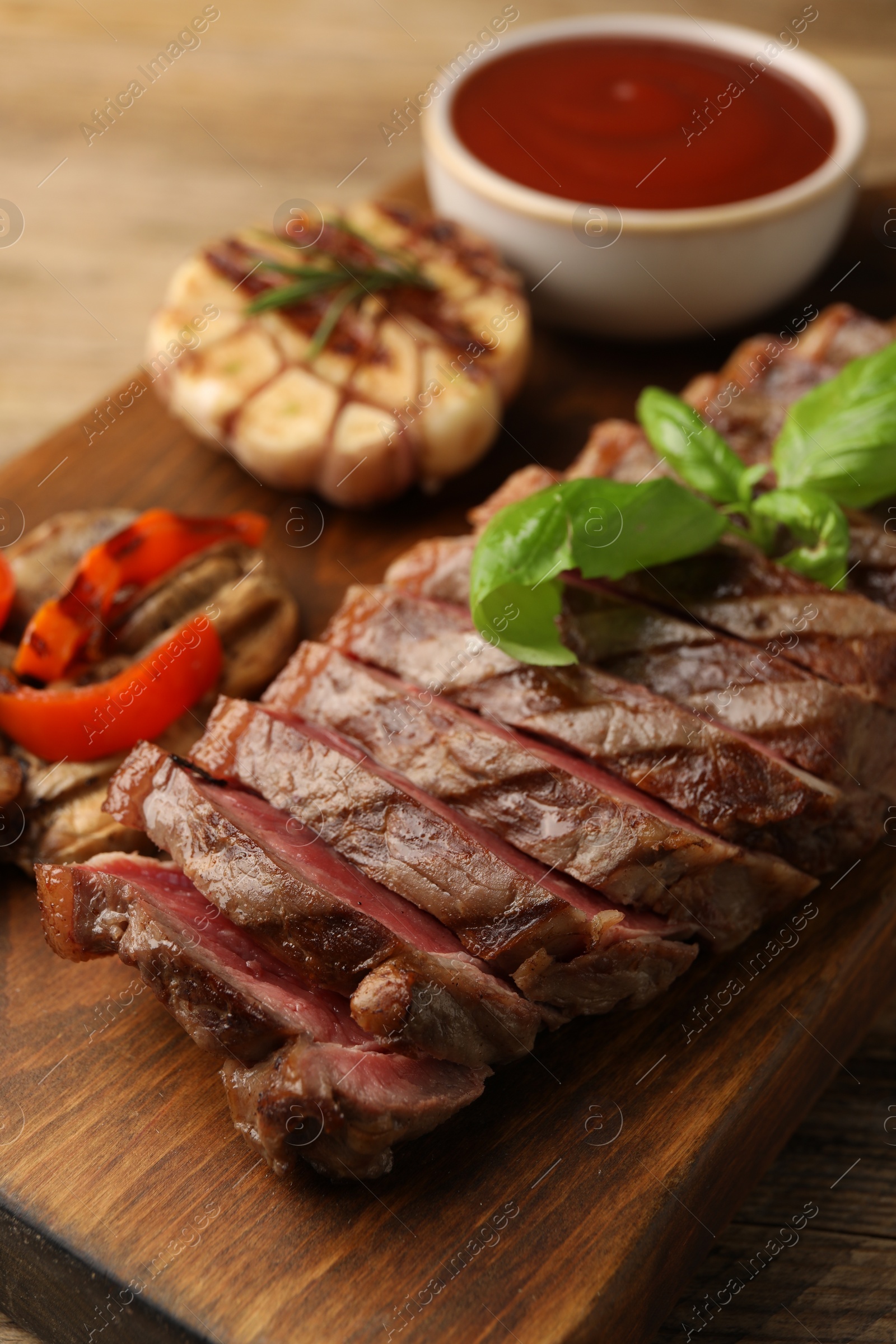 Photo of Delicious grilled beef steak with spices and tomato sauce on table, closeup