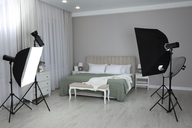 Photo of Professional photo studio equipment prepared for shooting bedroom interior