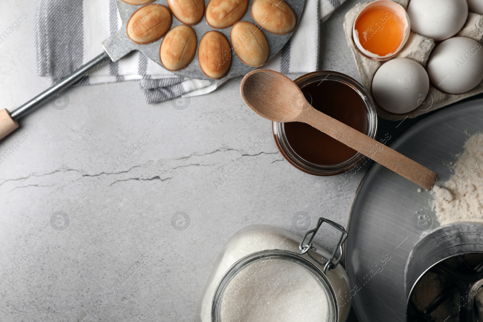 Photo of Freshly baked homemade walnut shaped cookies and ingredients on grey table, flat lay. Space for text