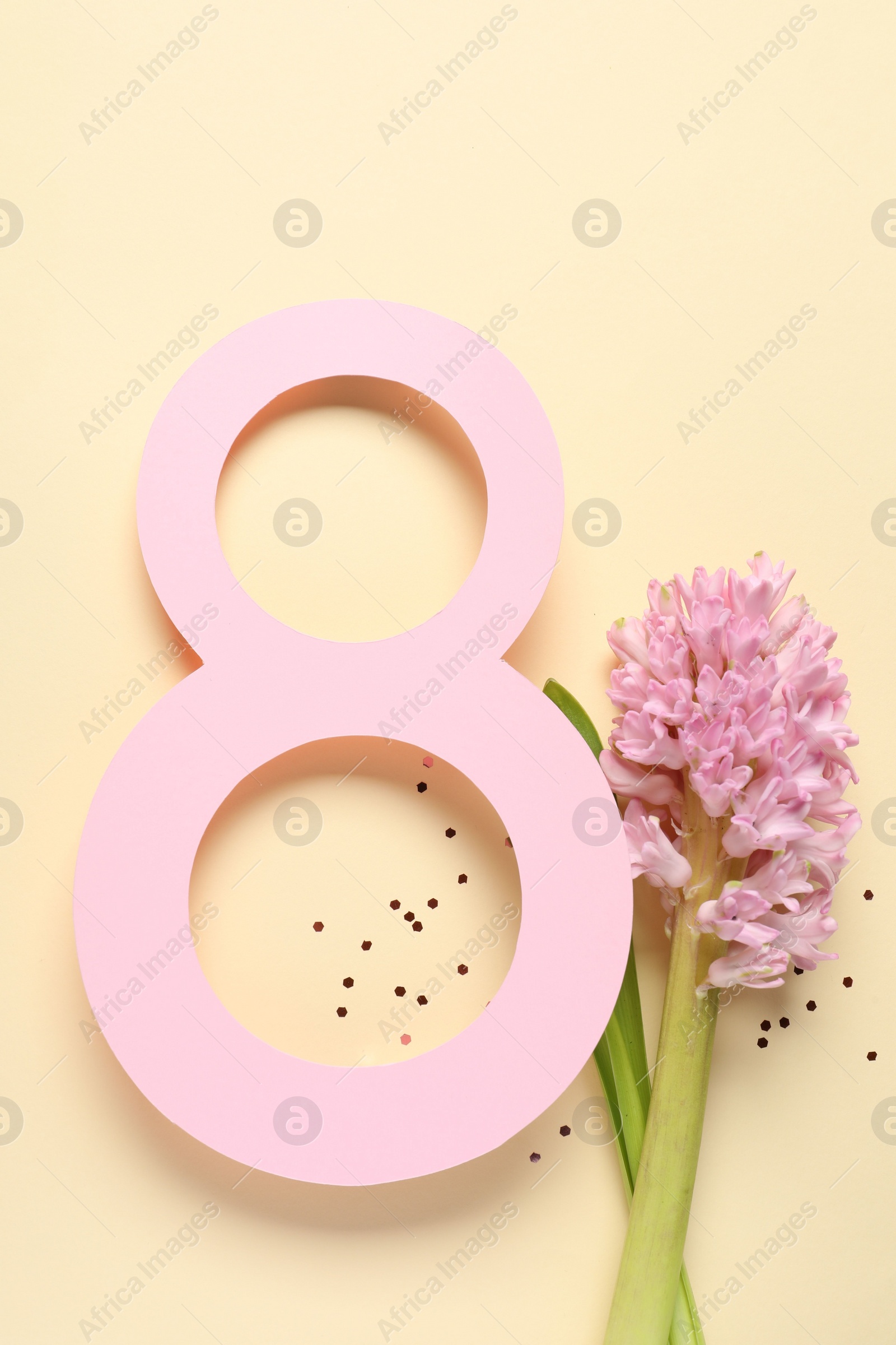 Photo of 8th of March greeting card design with paper number eight and beautiful flowers on beige background, flat lay. International Women's day