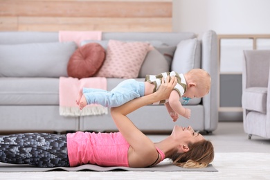 Young sportive woman doing exercise with her son at home. Fitness training