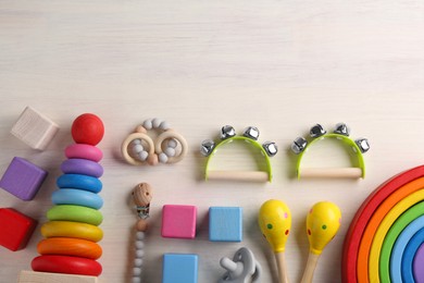 Baby song concept. Flat lay composition with toy musical instruments on white wooden background. Space for text