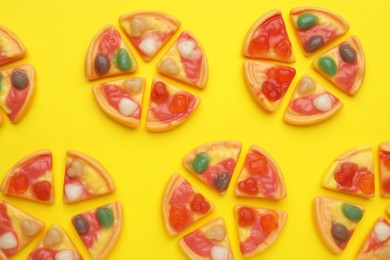 Tasty jelly candies in shape of pizza on yellow background, flat lay