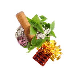 Photo of Mortar with fresh herbs and pills on white background, top view