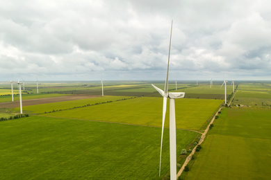 Aerial view of wind turbines in field on cloudy day