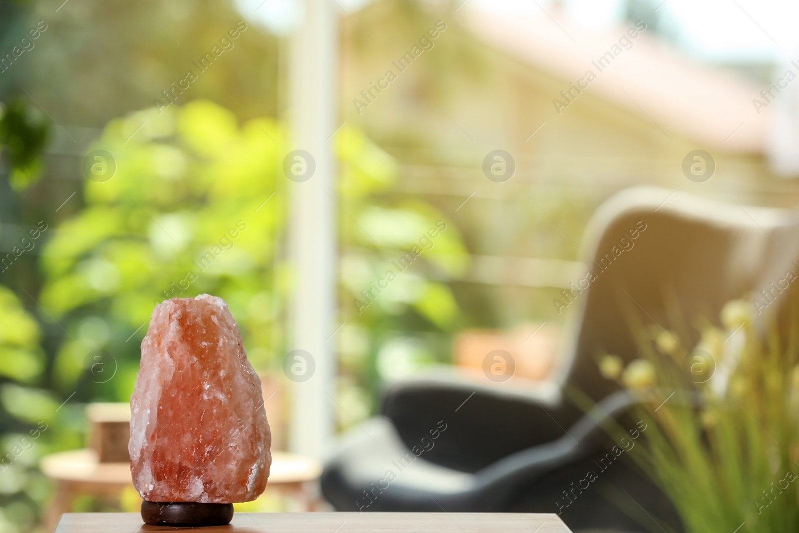 Photo of Himalayan salt lamp on table against blurred background