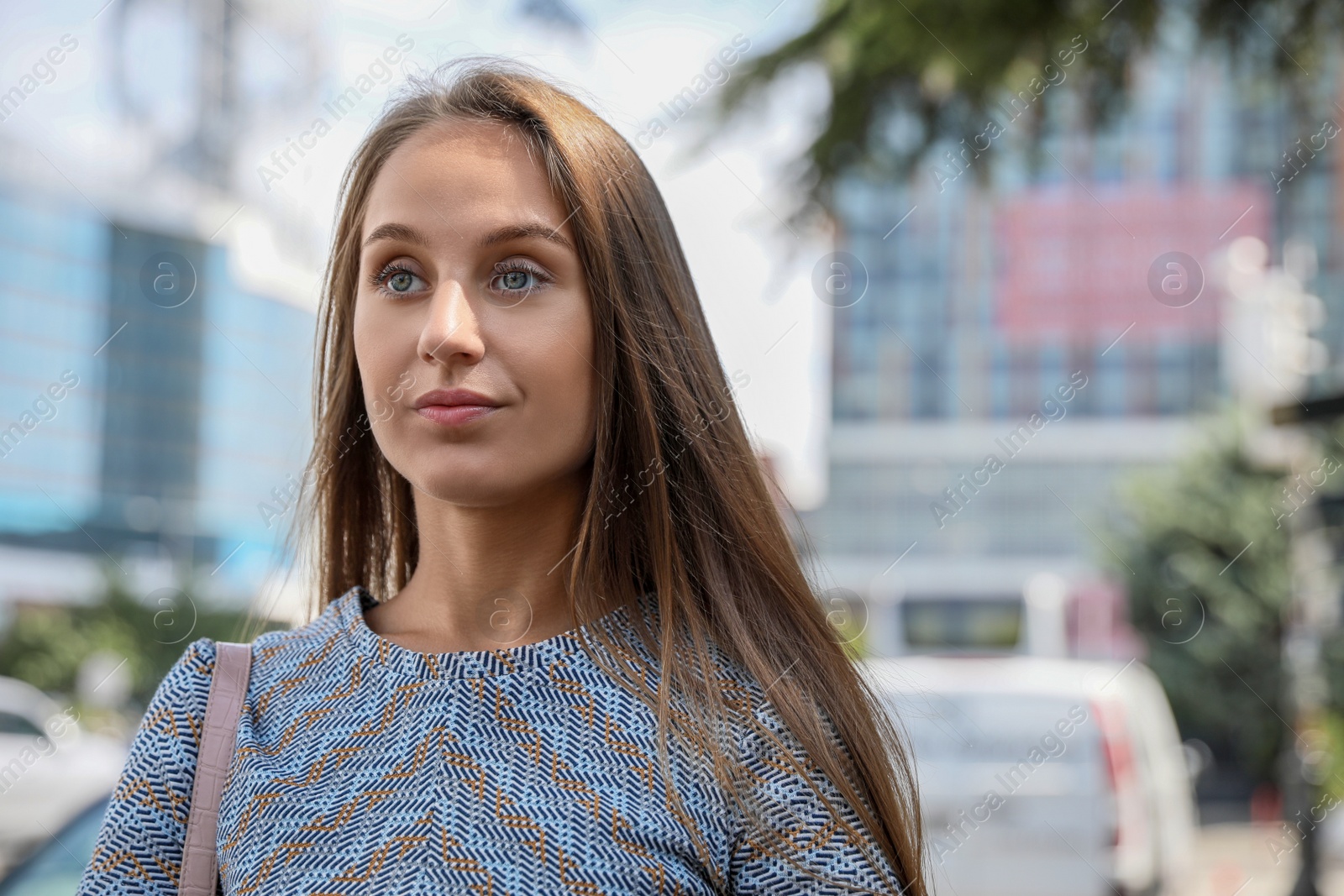 Photo of Beautiful young woman in stylish t-shirt outdoors, space for text