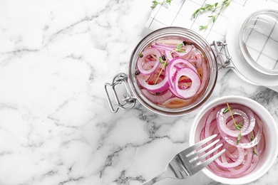 Flat lay composition with jar of pickled onions on marble table. Space for text