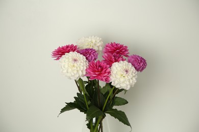 Photo of Bouquet of beautiful Dahlia flowers near white wall