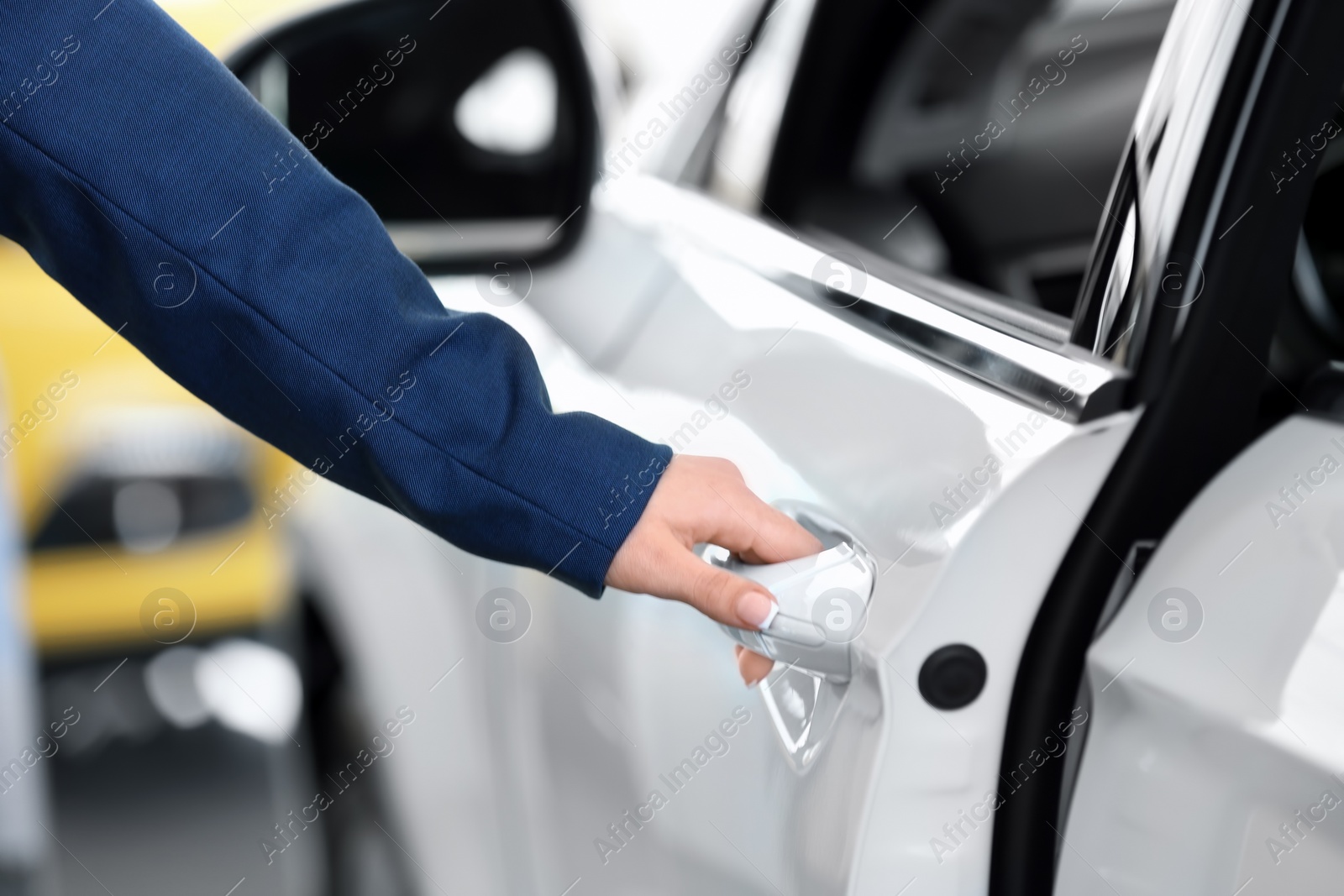 Photo of Young woman opening door of new car, closeup