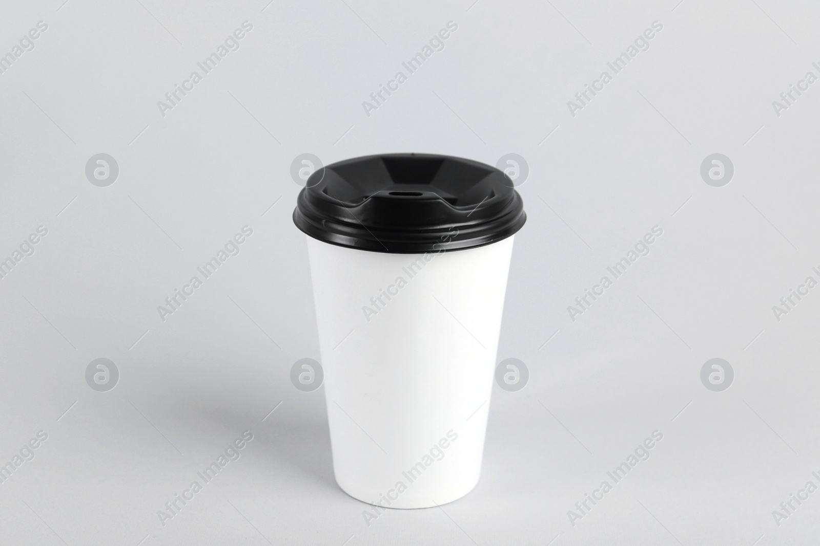 Photo of Paper cup with plastic lid on light background. Coffee to go