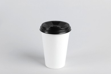 Paper cup with plastic lid on light background. Coffee to go