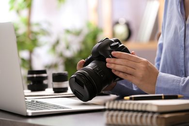 Photo of Journalist with camera working at table, closeup