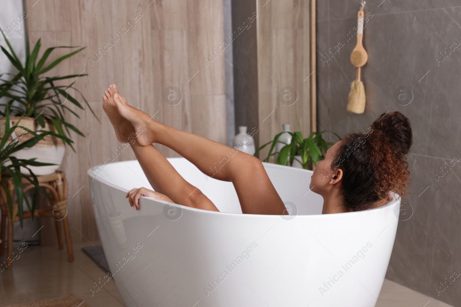 Photo of Beautiful African American woman taking bath indoors