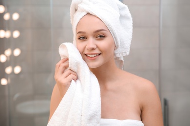 Beautiful woman with clean towels in bathroom