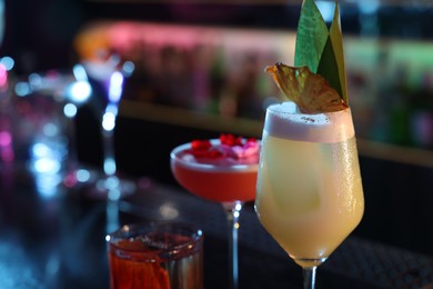 Photo of Different fresh alcoholic cocktails on blurred background, closeup. Space for text
