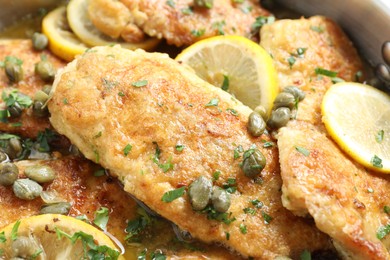 Delicious chicken piccata with herbs and lemons as background, closeup