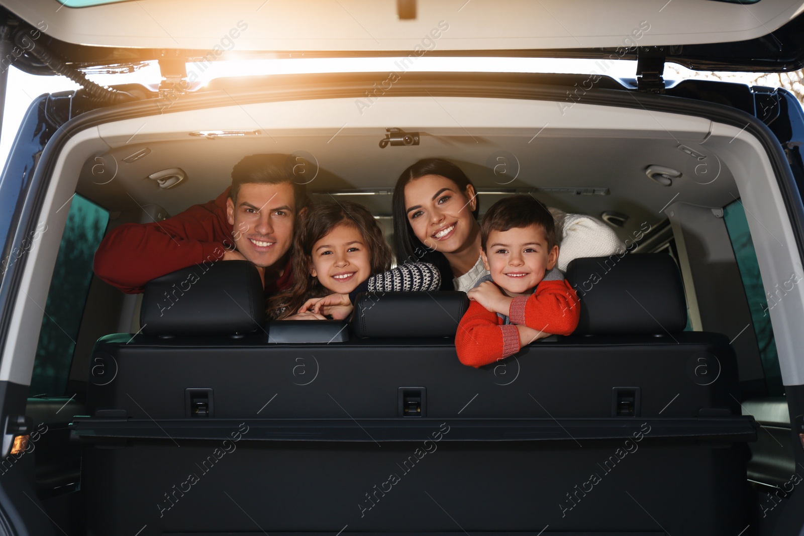 Photo of Happy family with little children inside modern car