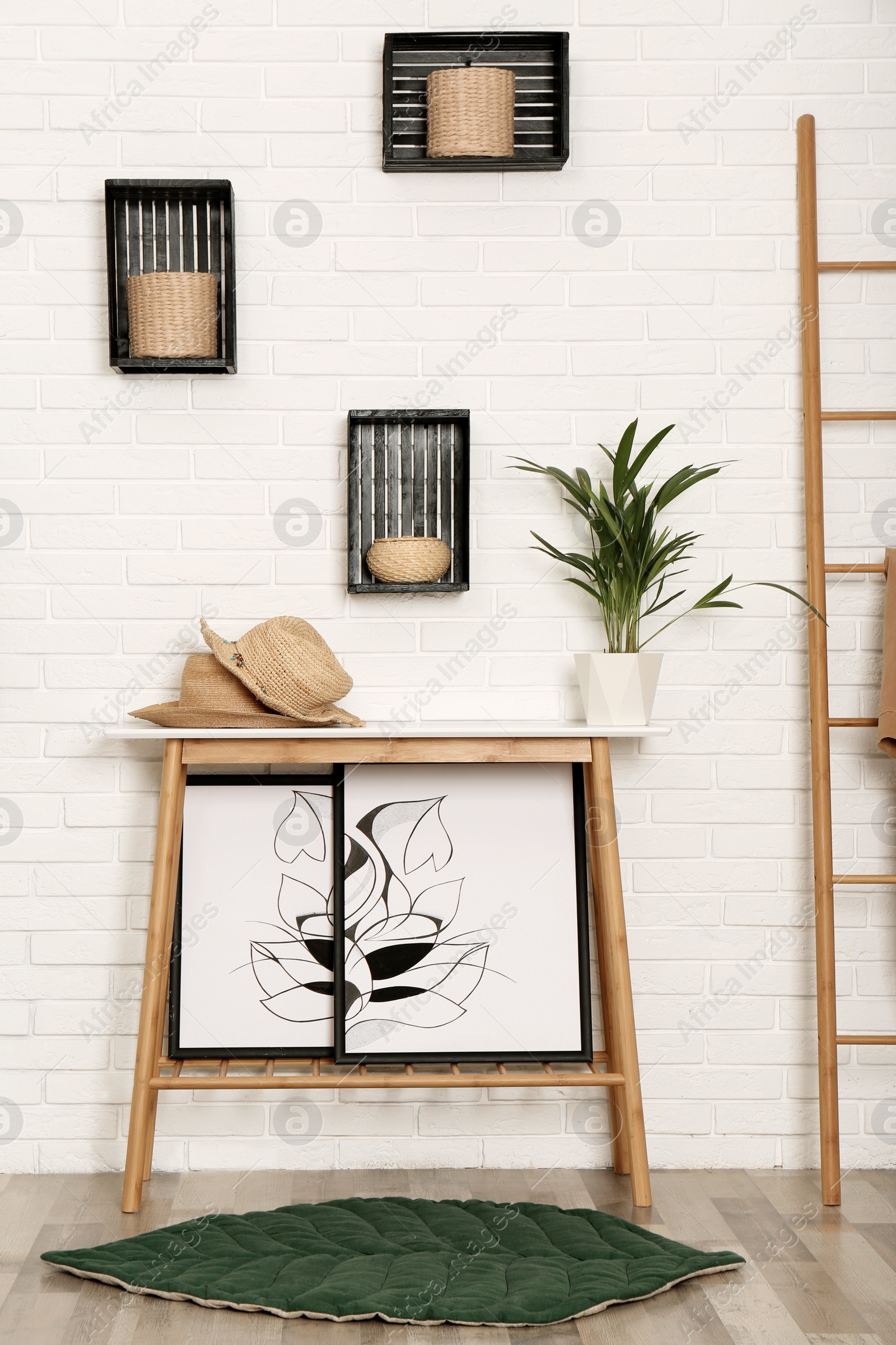 Photo of Stylish hallway interior with table and shelves on brick wall