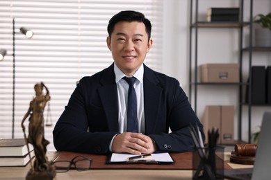 Photo of Happy notary working at wooden table in office