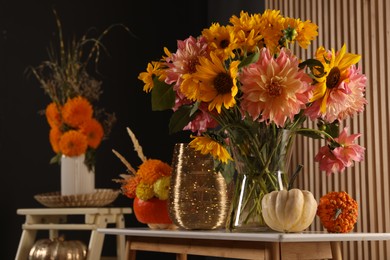 Room decorated with pumpkins and bright flowers, space for text. Autumn vibes