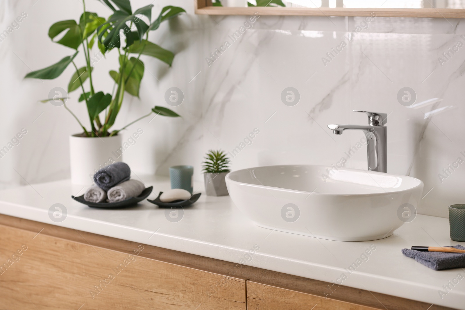 Photo of Stylish vessel sink on light countertop in modern bathroom