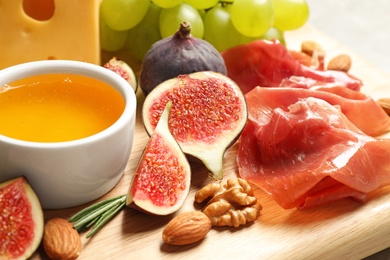 Photo of Set of different snacks with ripe figs served on board, closeup