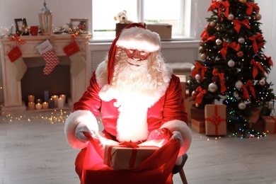 Authentic Santa Claus with bag of gifts indoors