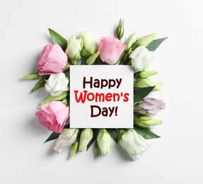 Image of Beautiful Eustoma flowers and card on white background, flat lay. Happy Women's Day