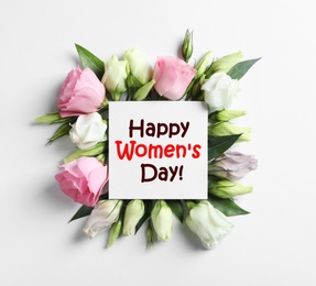 Beautiful Eustoma flowers and card on white background, flat lay. Happy Women's Day