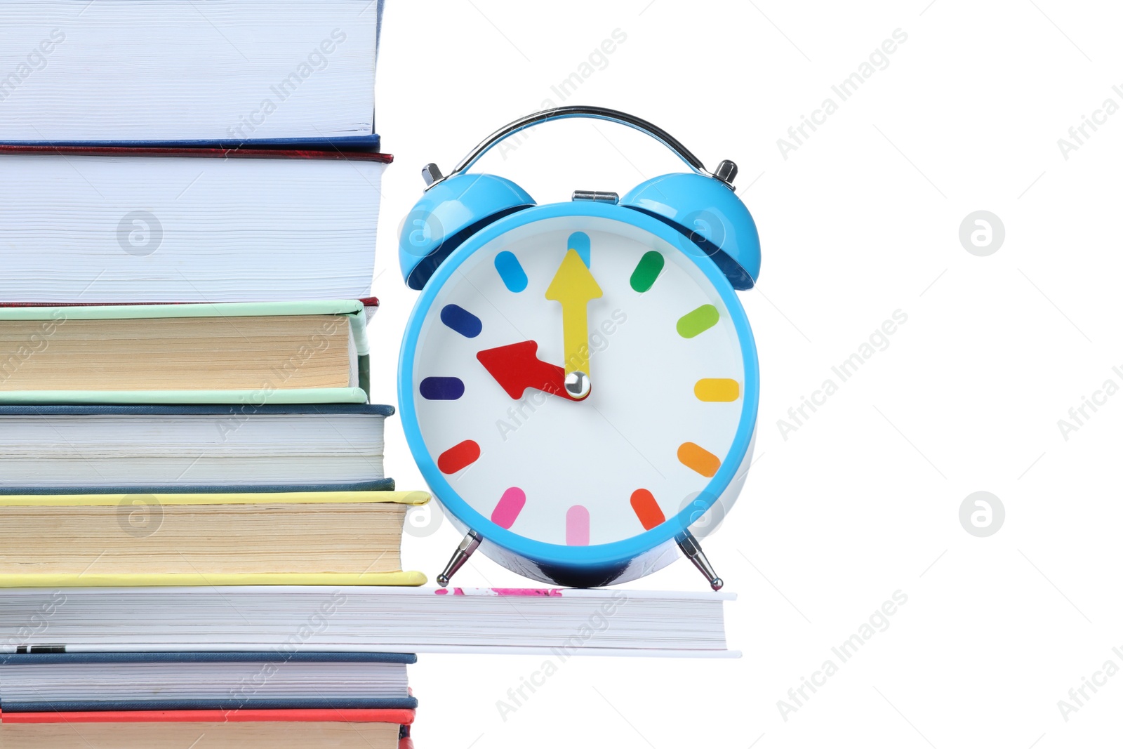 Photo of Light blue alarm clock and different books on white background. School time