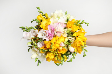 Photo of Beautiful colorful freesia bouquet on grey background, top view