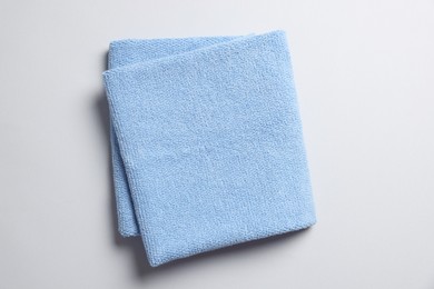 Photo of Soft folded light blue towel on light grey background, top view