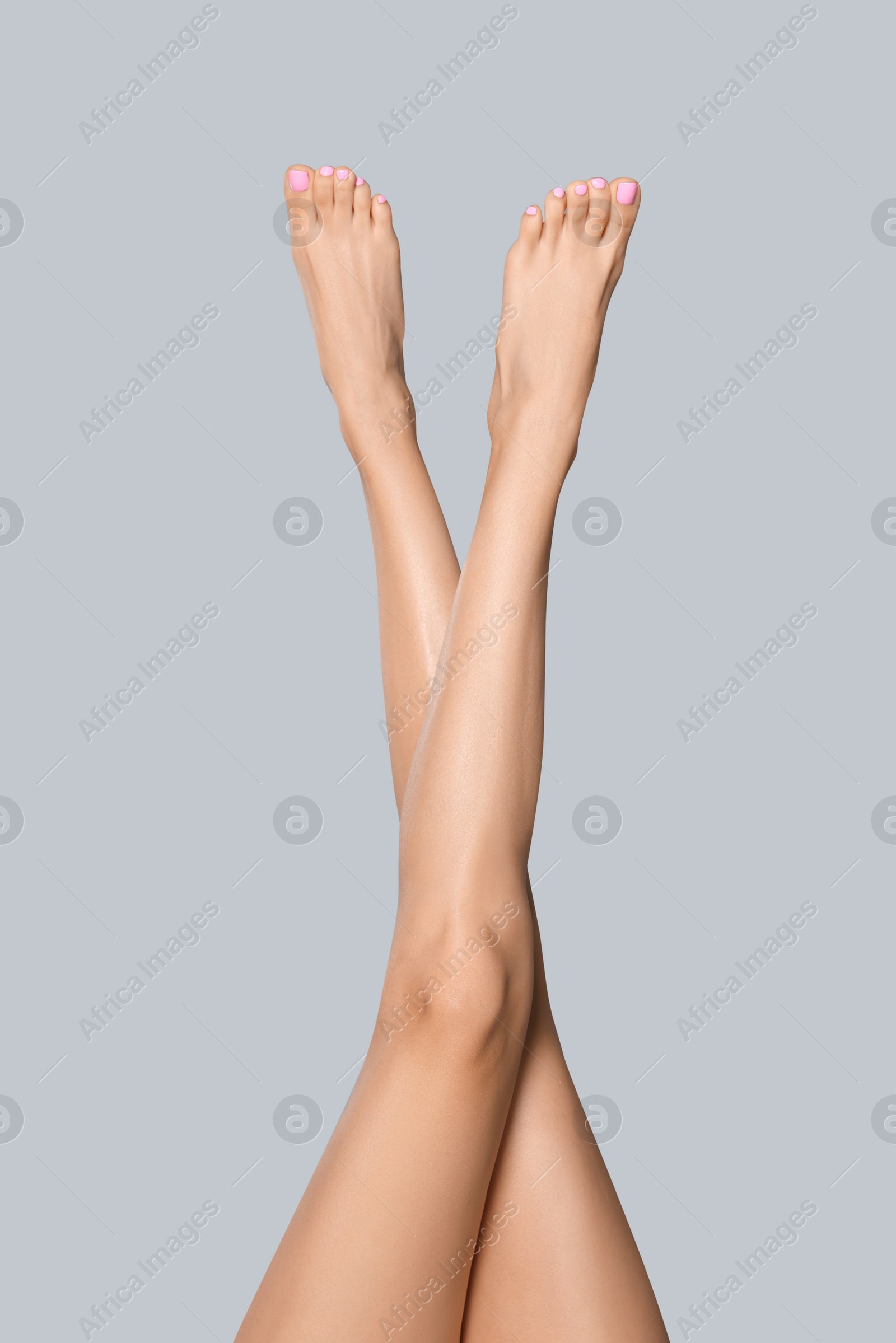 Photo of Woman with beautiful long legs on grey background, closeup