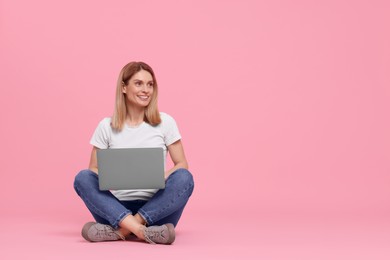 Photo of Happy woman with laptop on pink background. Space for text