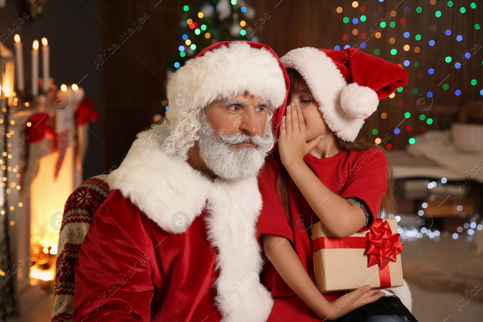 Photo of Little child with Santa Claus and Christmas gift at home